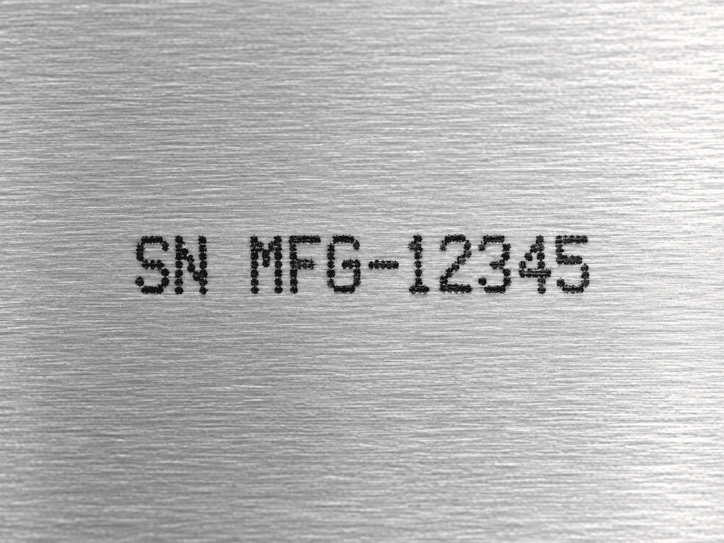 Close-up serial number printed on brushed metal
